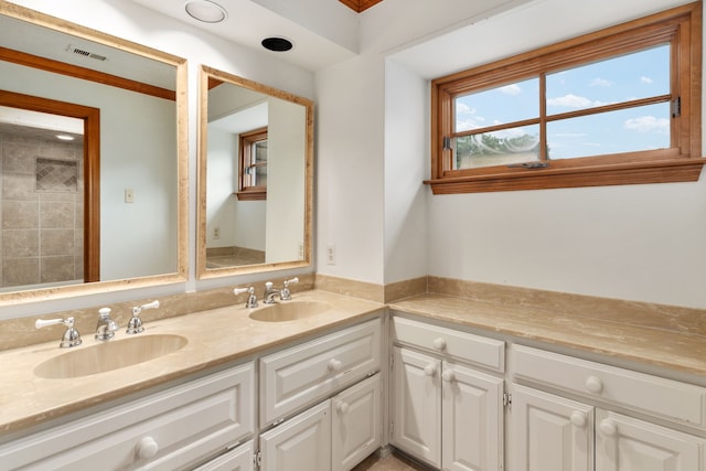 bathroom featuring visible vents, a sink, and double vanity