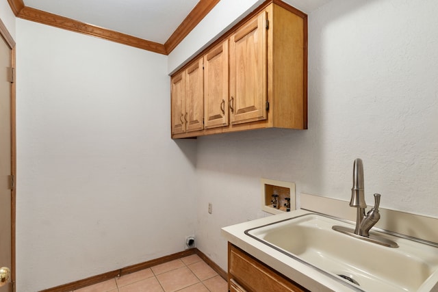 washroom featuring cabinet space, crown molding, a sink, hookup for a washing machine, and hookup for an electric dryer