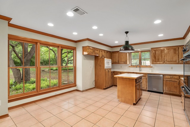 kitchen featuring dishwasher, light countertops, brown cabinetry, white microwave, and visible vents