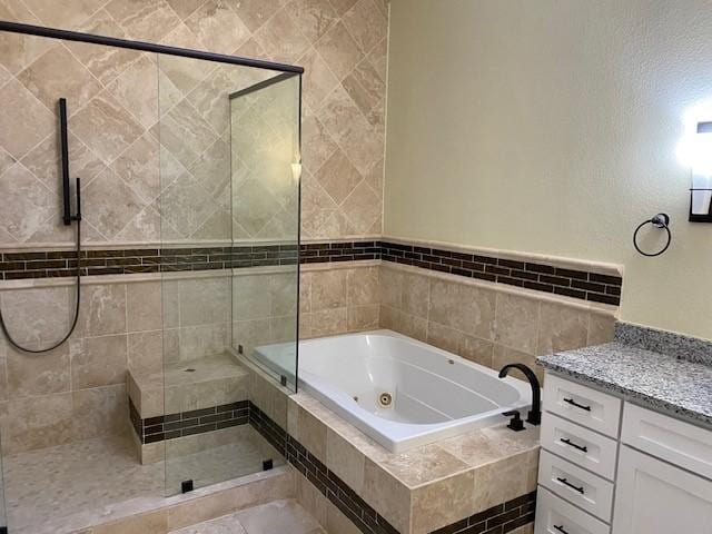 bathroom featuring a whirlpool tub, a shower stall, and vanity