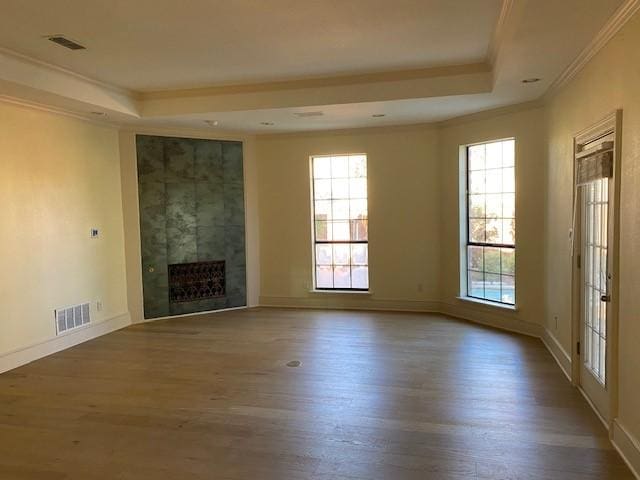 unfurnished living room with visible vents, crown molding, and a tray ceiling