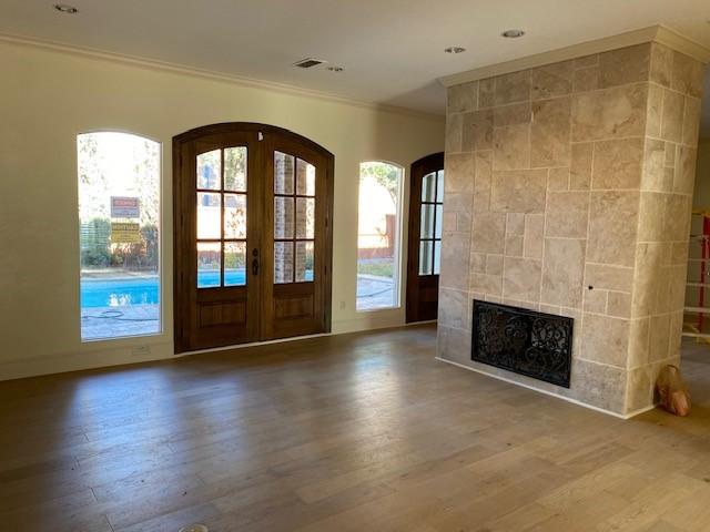 foyer entrance featuring arched walkways, ornamental molding, wood finished floors, and a wealth of natural light