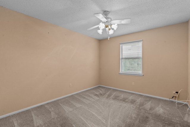 carpeted spare room featuring baseboards, a ceiling fan, and a textured ceiling