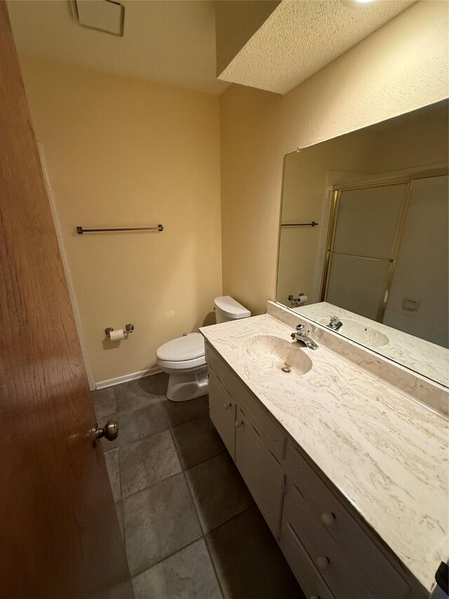 unfurnished bedroom featuring a walk in closet, baseboards, carpet flooring, and a textured ceiling