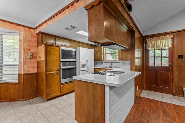 kitchen featuring brown cabinetry, visible vents, stainless steel oven, black electric cooktop, and a textured ceiling