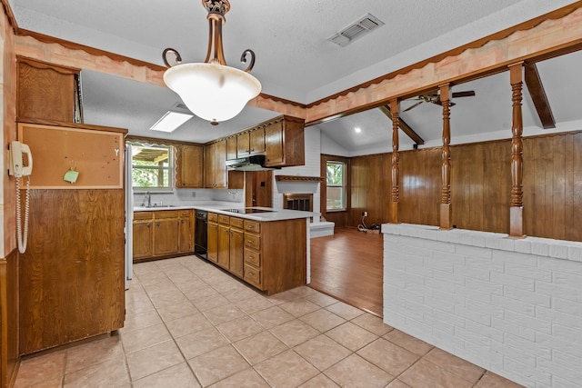 kitchen featuring brown cabinetry, visible vents, light countertops, black appliances, and lofted ceiling