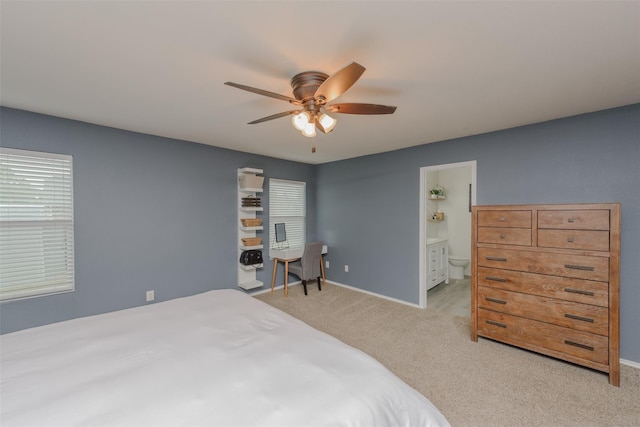 bedroom with light colored carpet, connected bathroom, and baseboards