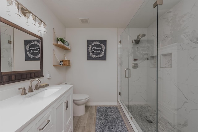 full bath featuring a marble finish shower, toilet, vanity, and wood finished floors