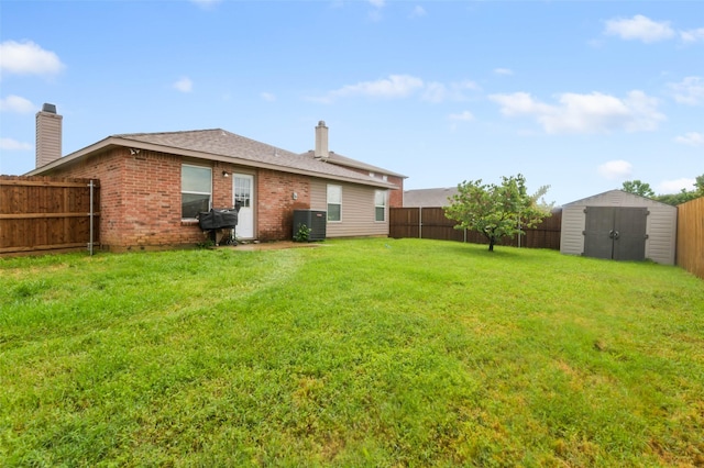 view of yard with a storage shed, an outdoor structure, a fenced backyard, and cooling unit