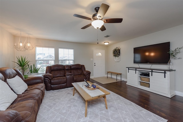 living area with ceiling fan, baseboards, visible vents, and wood finished floors