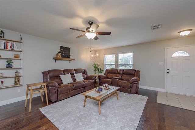 living area featuring baseboards, ceiling fan, wood-type flooring, and visible vents