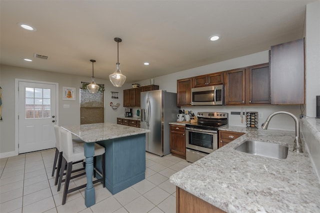 kitchen with appliances with stainless steel finishes, a sink, a center island, light tile patterned floors, and recessed lighting