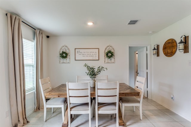 dining room featuring light tile patterned flooring, visible vents, and plenty of natural light