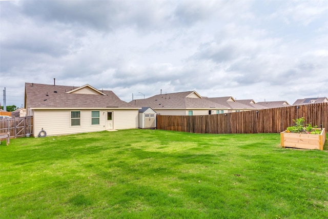 view of yard with a storage unit, a fenced backyard, an outbuilding, and a vegetable garden