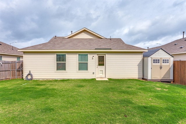 rear view of house featuring a storage unit, a fenced backyard, an outbuilding, and a yard