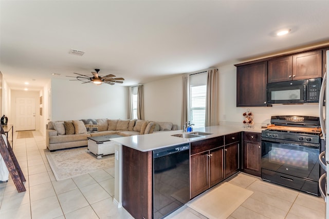 kitchen with a ceiling fan, a sink, black appliances, a peninsula, and light tile patterned flooring