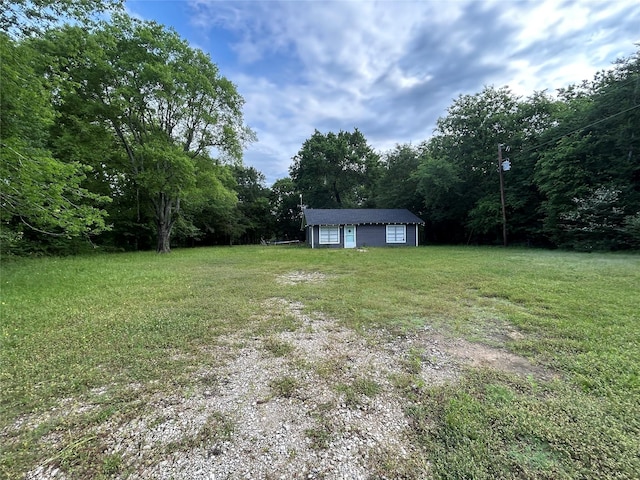 view of yard with a forest view and a detached garage