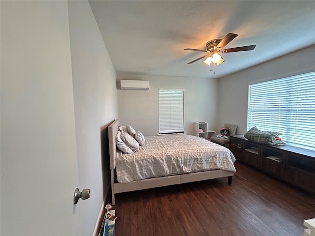 bedroom with ceiling fan, dark wood-type flooring, and a wall mounted air conditioner
