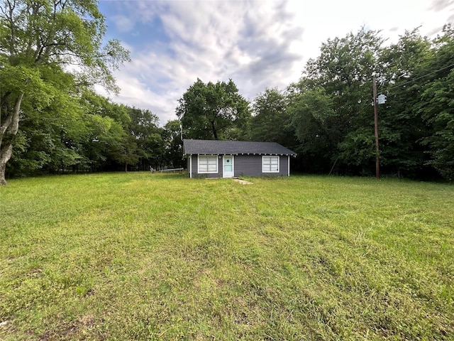 view of yard featuring a view of trees and an outbuilding