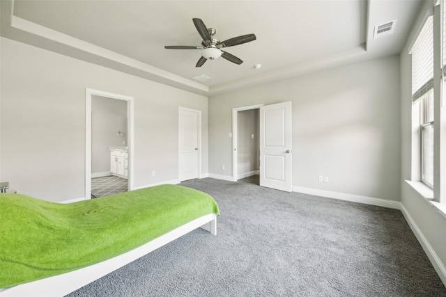 2900 Inn Kitchen Way, Mckinney, TX 75071 - carpeted bedroom featuring a tray ceiling, baseboards, ensuite bath, and a ceiling fan