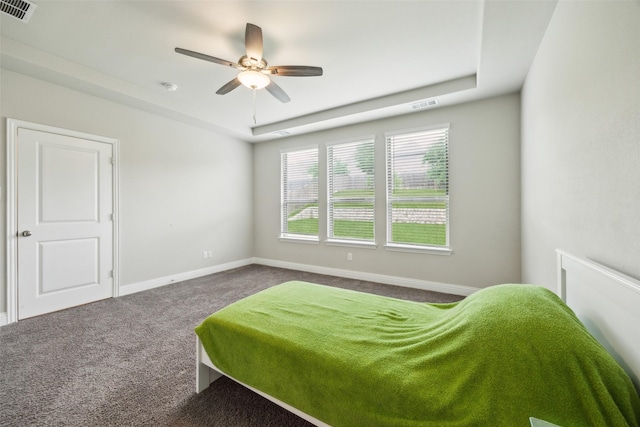 bedroom with visible vents, baseboards, carpet floors, and a tray ceiling