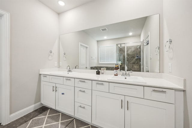full bathroom featuring double vanity, visible vents, a shower stall, and a sink