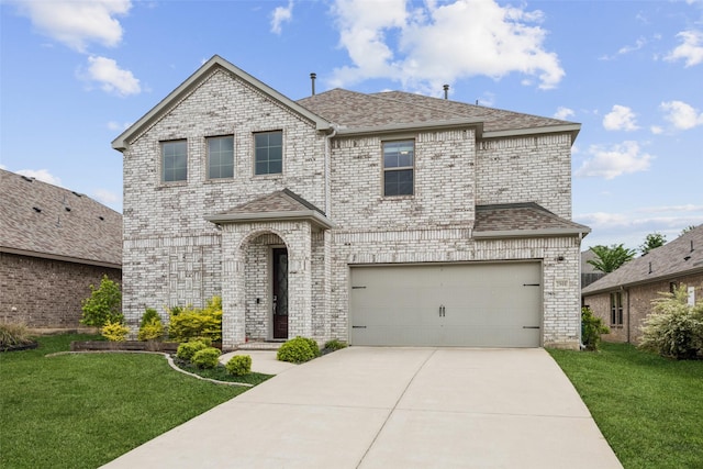 french country home with roof with shingles, an attached garage, brick siding, a front yard, and concrete driveway