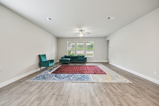 living area with ceiling fan, wood finished floors, and visible vents