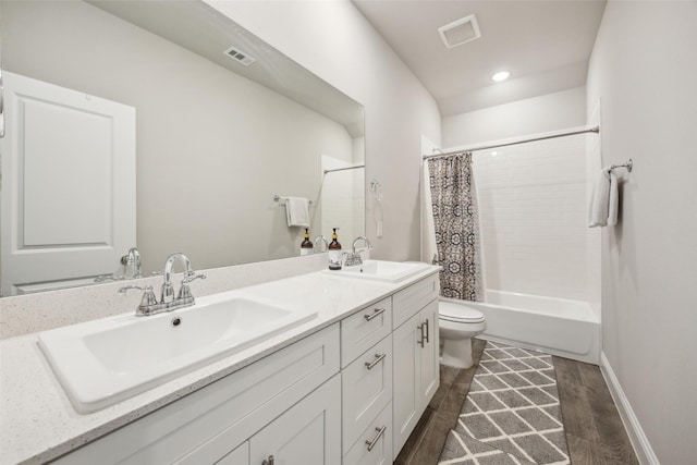 full bath with a sink, toilet, wood finished floors, and visible vents