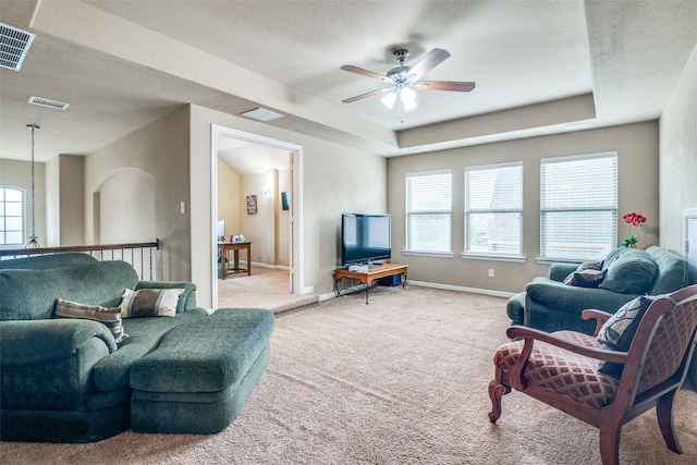 living room with carpet floors, a ceiling fan, and visible vents
