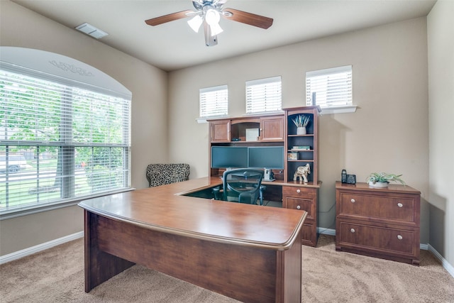office area with a ceiling fan, baseboards, visible vents, and light carpet