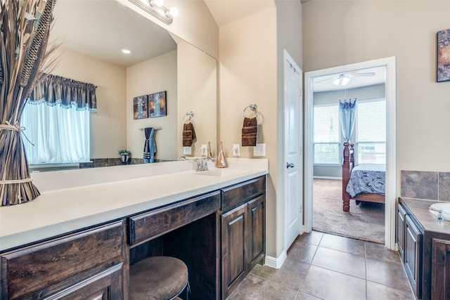 ensuite bathroom with ceiling fan, tile patterned flooring, vanity, baseboards, and connected bathroom