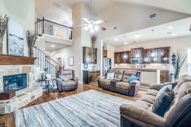 living area with visible vents, wood finished floors, stairway, and a fireplace