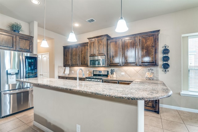 kitchen featuring appliances with stainless steel finishes, backsplash, dark brown cabinets, and visible vents