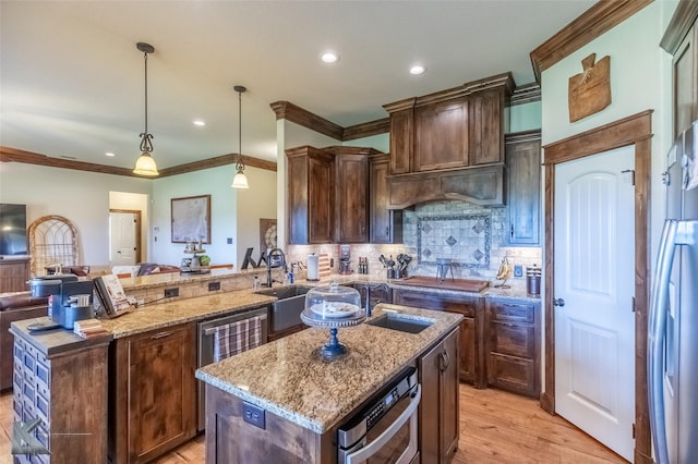 kitchen with ornamental molding, a sink, a center island with sink, and light stone countertops