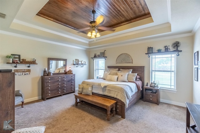 bedroom featuring a raised ceiling, multiple windows, ornamental molding, and carpet floors