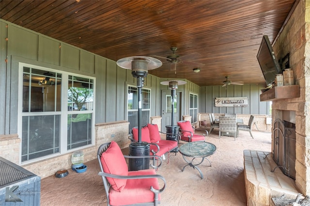 view of patio with a ceiling fan and an outdoor stone fireplace