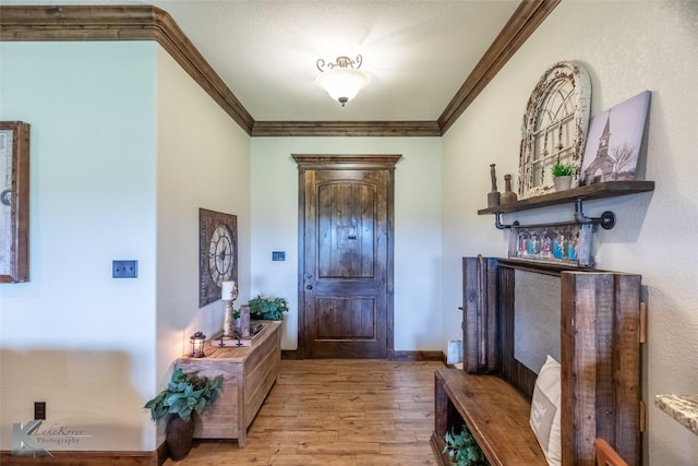 entryway featuring crown molding and wood finished floors