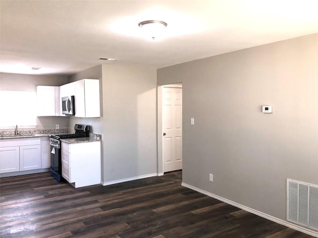 kitchen with visible vents, white cabinetry, light stone counters, a sink, and stainless steel appliances