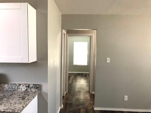 corridor with baseboards and dark wood finished floors