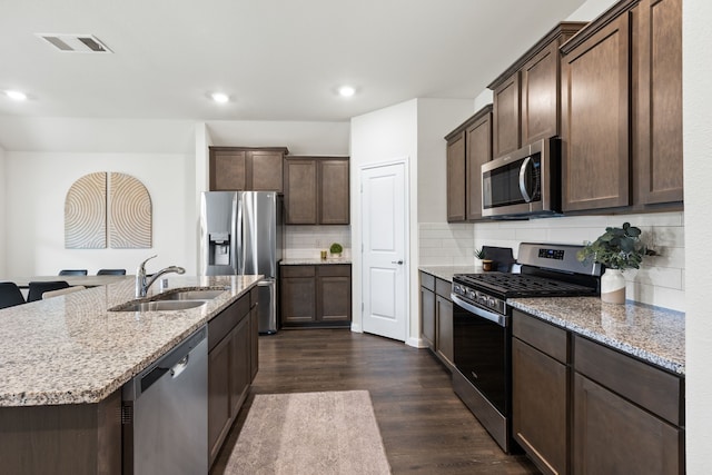 604 Stampede Ln, Princeton, TX 75407 - kitchen featuring appliances with stainless steel finishes, a sink, dark wood-style floors, dark brown cabinets, and tasteful backsplash