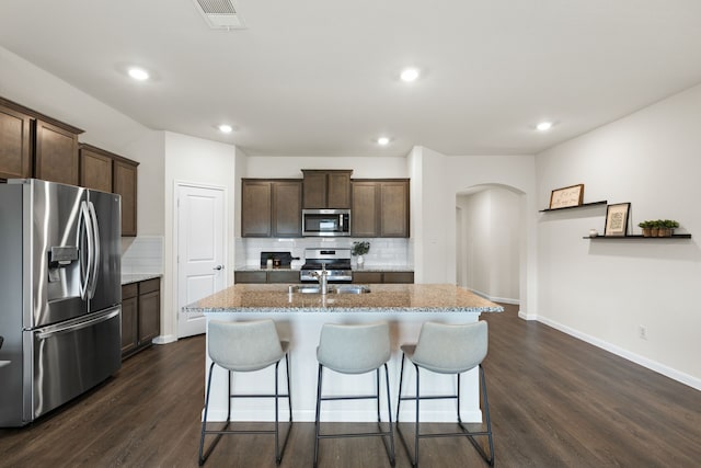 604 Stampede Ln, Princeton, TX 75407 - kitchen with appliances with stainless steel finishes, arched walkways, decorative backsplash, dark wood-style flooring, and recessed lighting