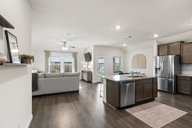 604 Stampede Ln, Princeton, TX 75407 - kitchen featuring appliances with stainless steel finishes, open floor plan, dark wood finished floors, light stone counters, and recessed lighting
