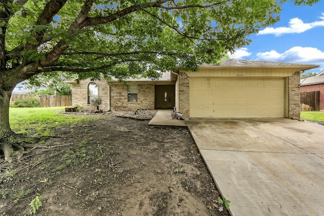 view of front of home featuring brick siding, a garage, fence, and concrete driveway