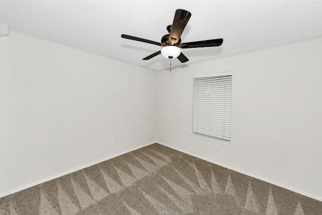 spare room featuring dark carpet, baseboards, and ceiling fan