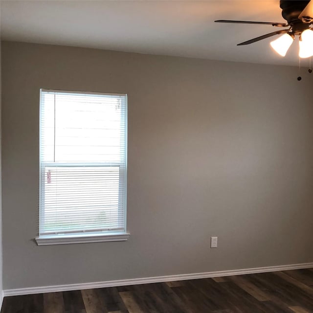 unfurnished room with a ceiling fan, baseboards, and dark wood finished floors