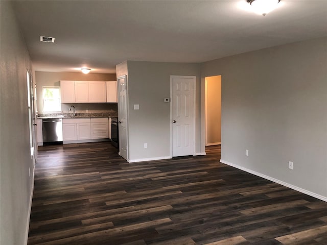kitchen featuring stainless steel dishwasher, a sink, and baseboards