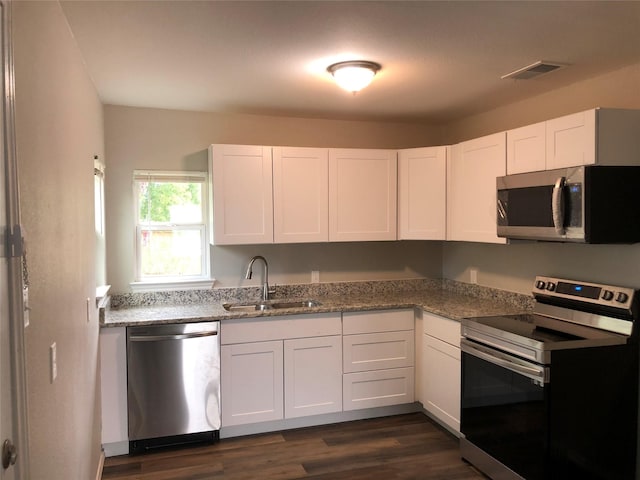 kitchen with white cabinets, stainless steel appliances, visible vents, and a sink