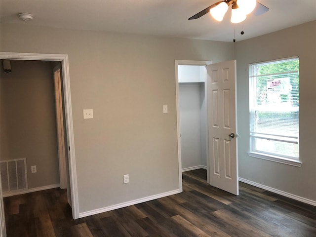 unfurnished bedroom with visible vents, baseboards, and dark wood-type flooring