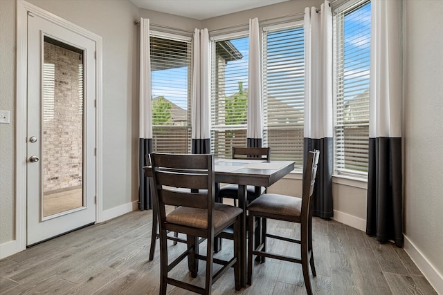 dining area with baseboards and wood finished floors
